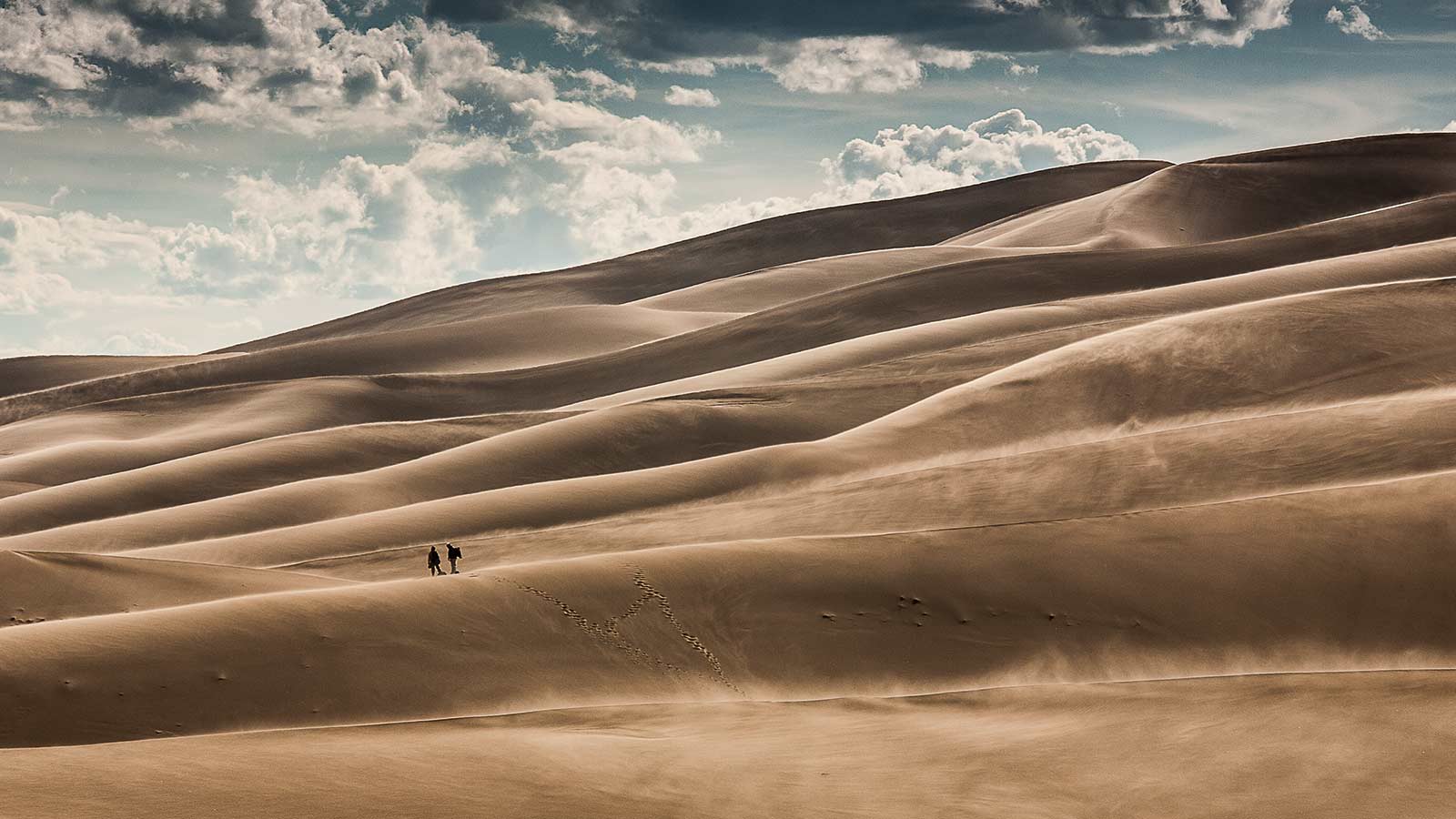 Hikers brave the windswept sand at Great Sand Dunes National Park