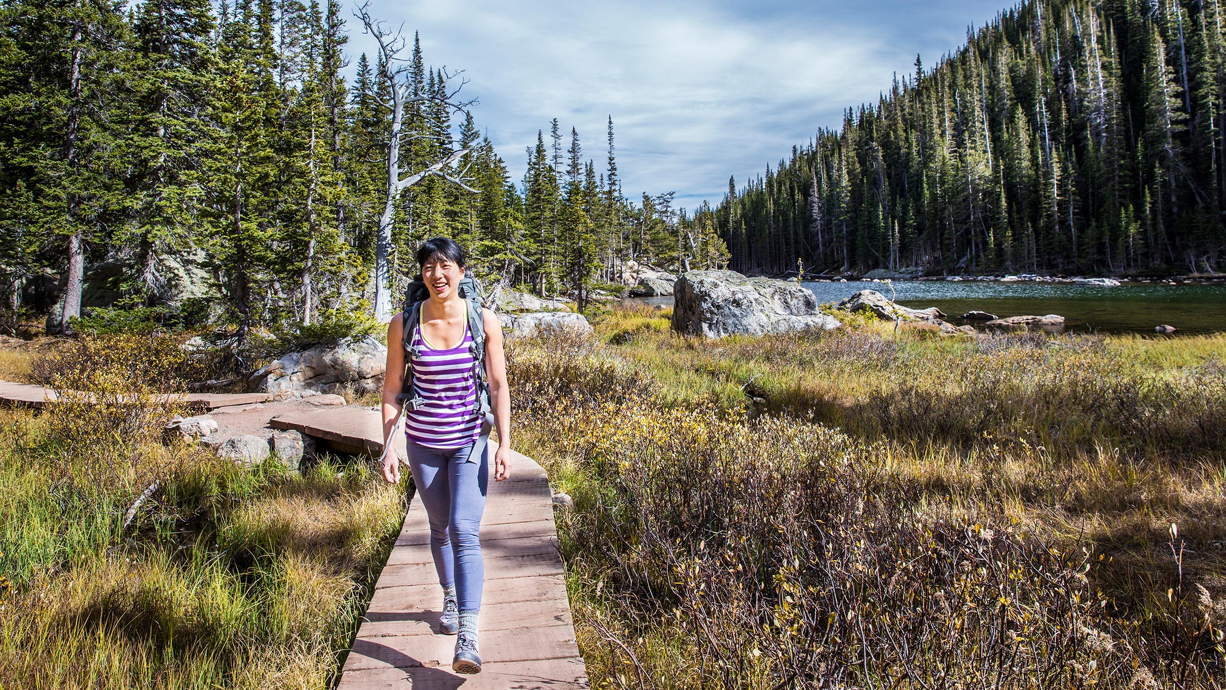 Woman taking a walk around a lake at Rocky Mountain National Park