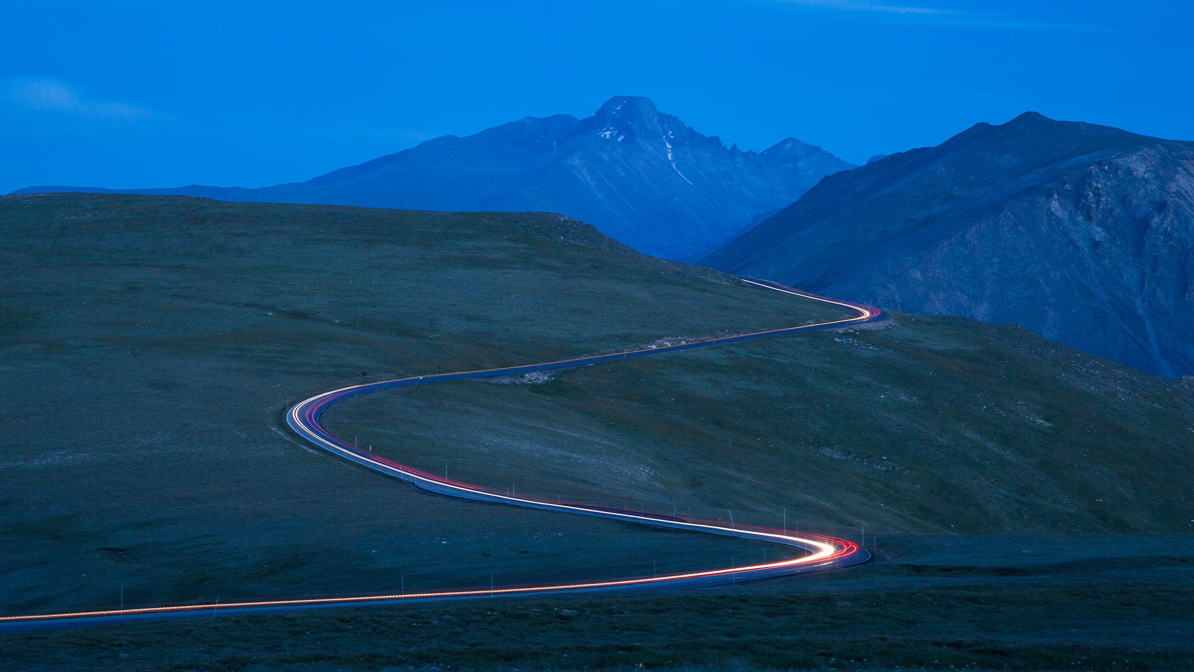 Car lights illuminate Trail Ridge Road at night in Rocky Mountain National Park