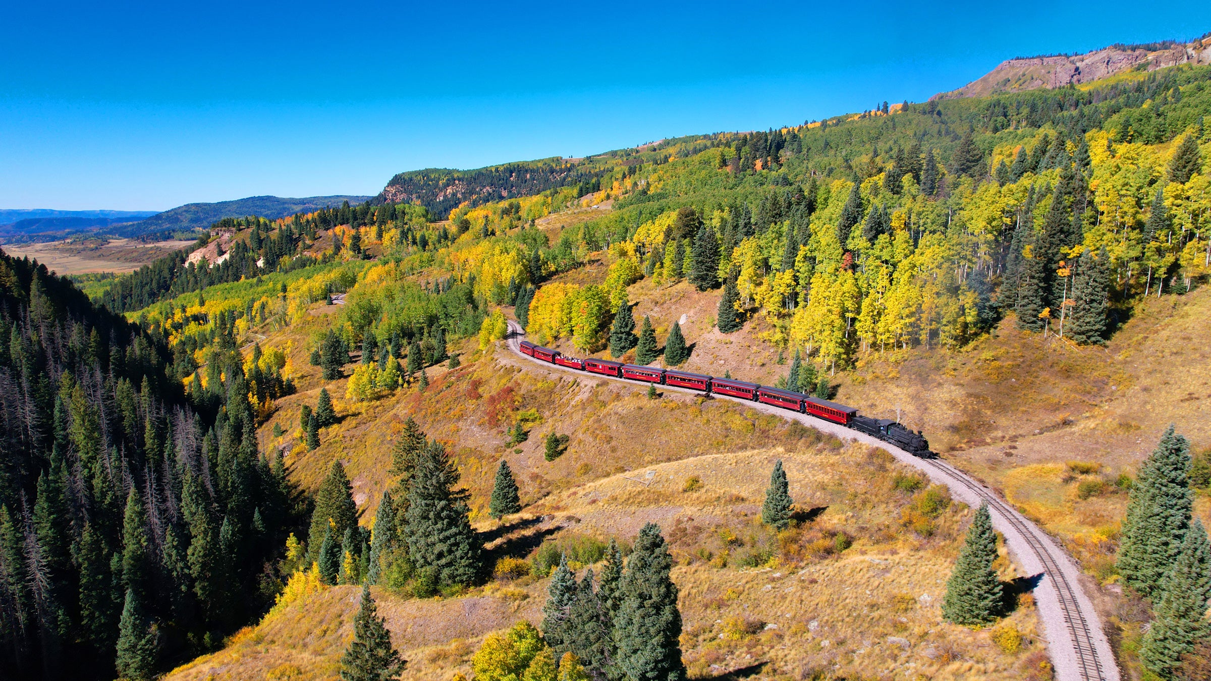 A train winds through the Rockies on the Cumbres & Toltec Scenic Railroad
